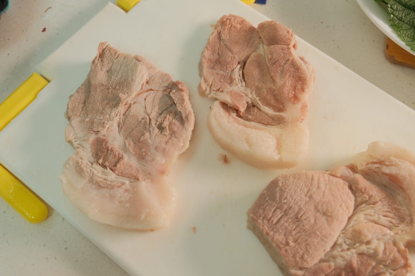 Cooked bossam pork sliced on a cutting board