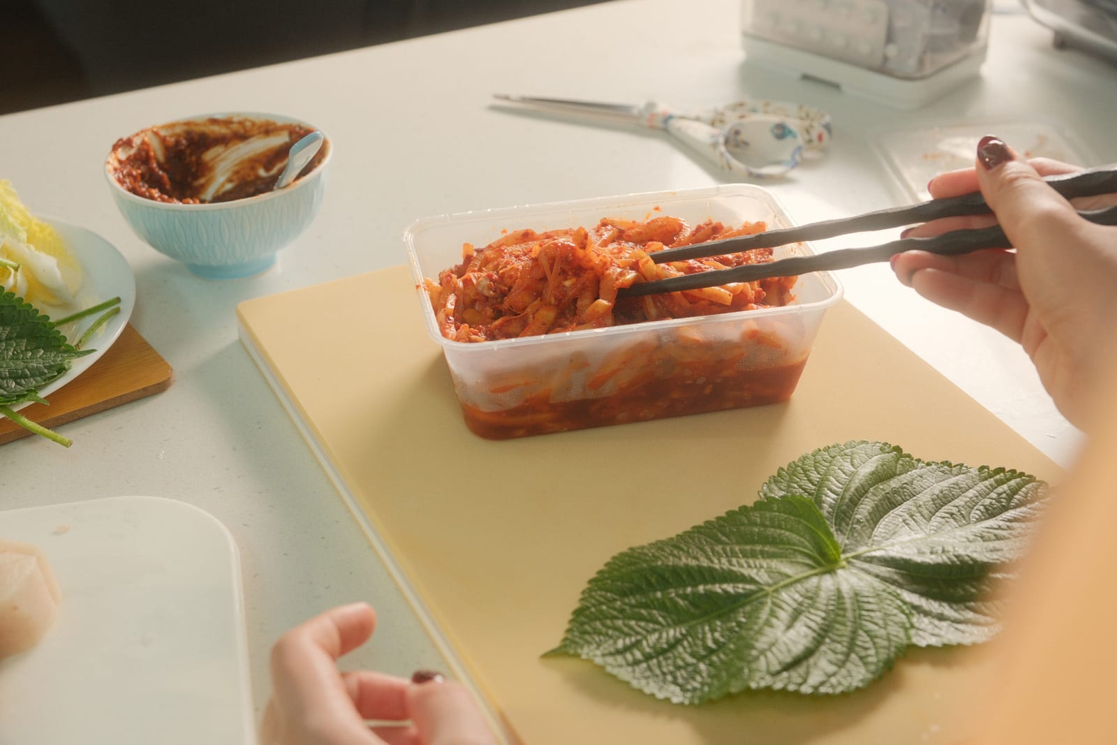 Mu saengchae radish salad being picked up with chopsticks