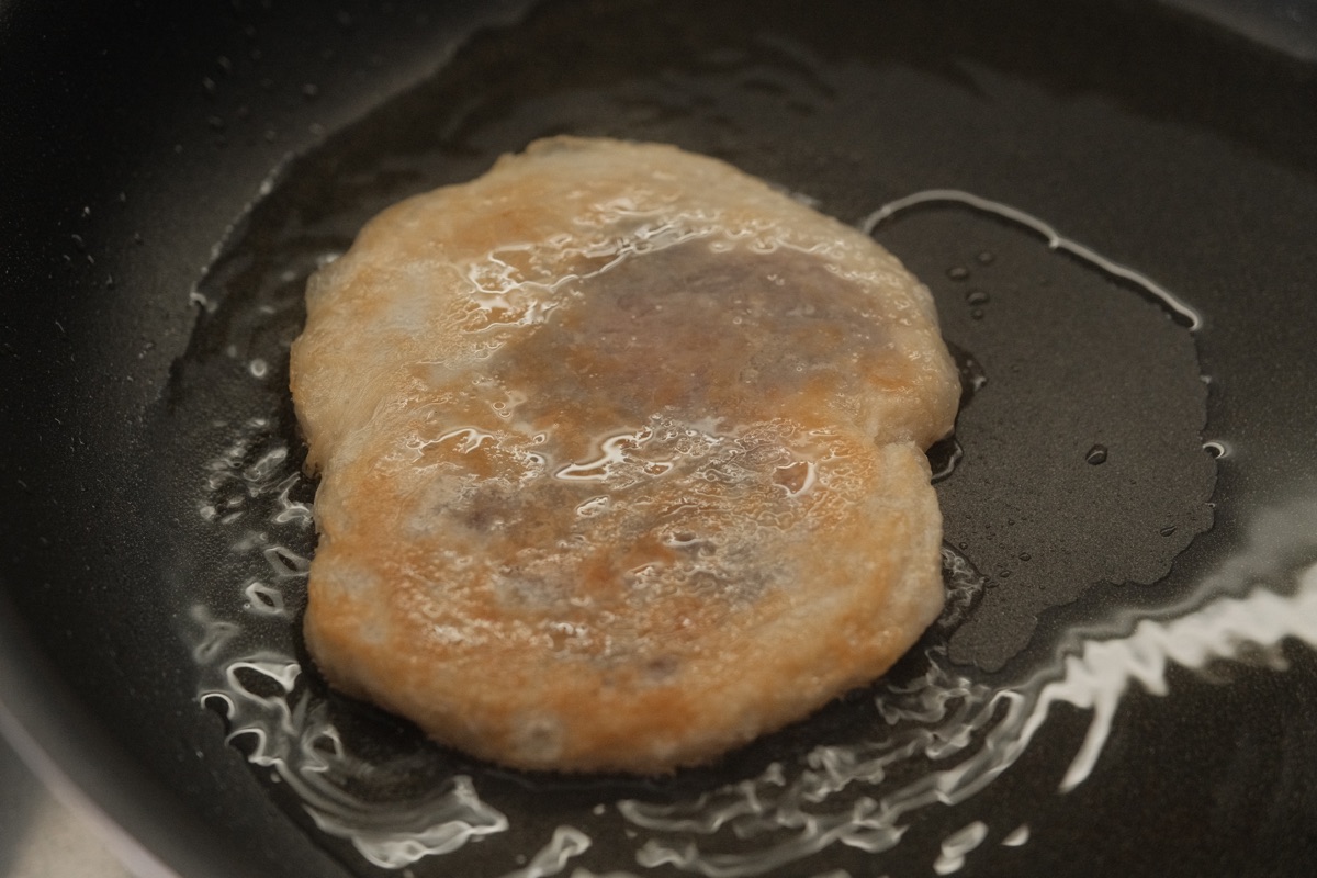Frozen paratha hotteok frying in a lightly oiled pan