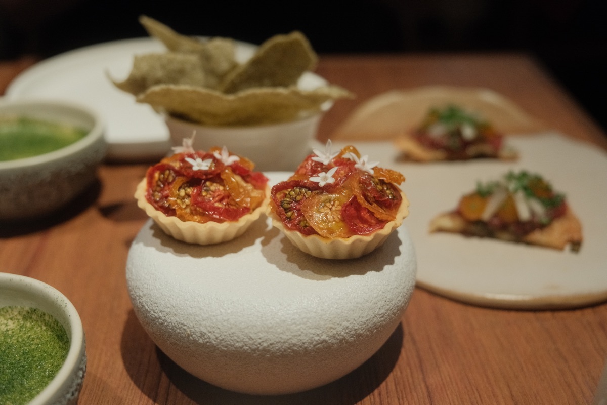 GU:UM opening bites arranged across ceramic plates on the dining table