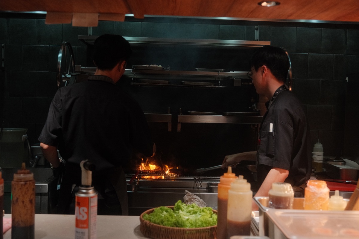 GU:UM chefs cooking over the open charcoal grill in the restaurant kitchen