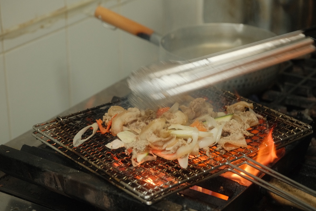 Pork and vegetables being finished over the charcoal grill at Jangsan Kisa Sikdang