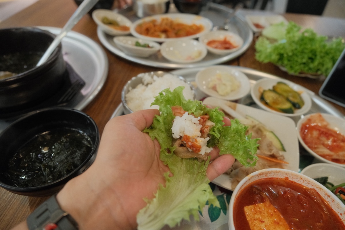 A lettuce ssam filled with smoky pork, rice and sauce