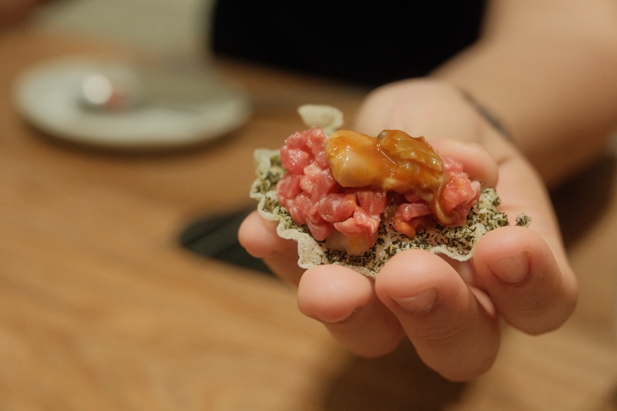 Yukhoe loaded onto bugak with oyster jeotgal