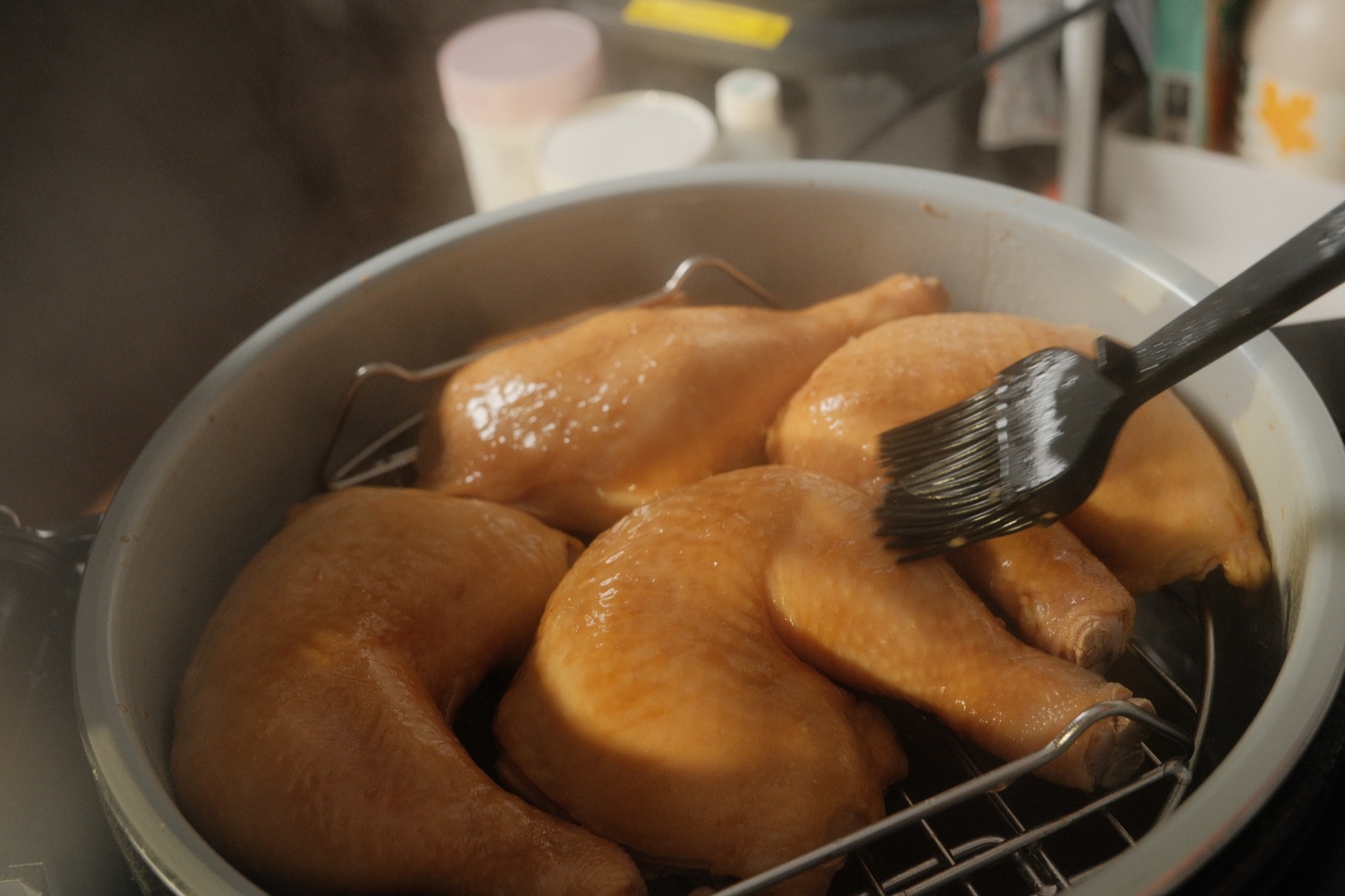 Steamed chicken being brushed with more marinade