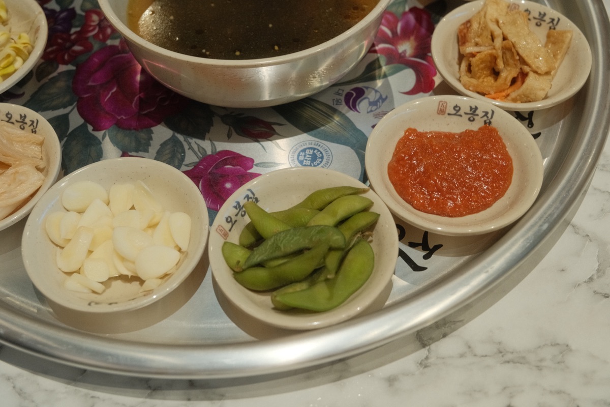 Garlic, edamame, dipping sauce and banchan served at Obongzip