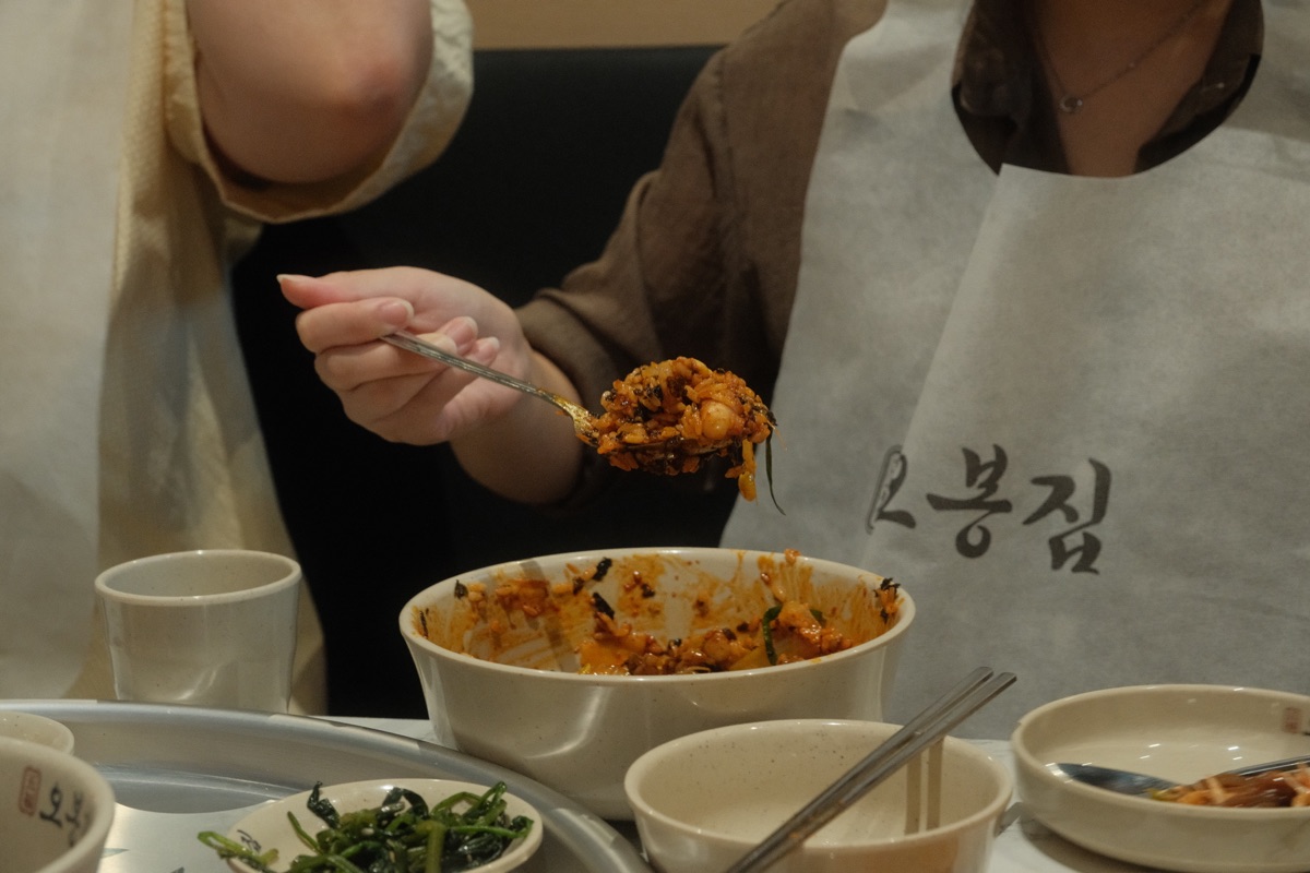 A spoonful of fried rice lifted from the finished octopus sauce