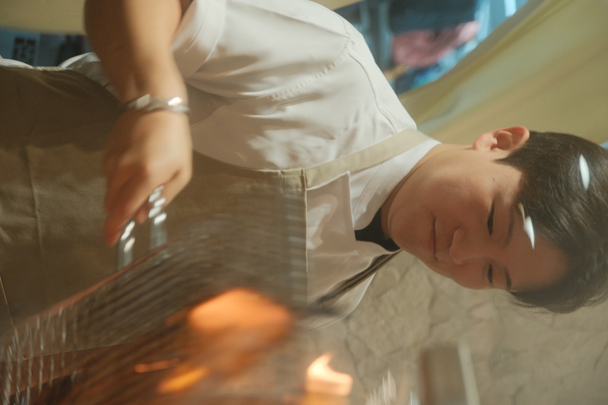 Chef working over the open charcoal grill at Sansok