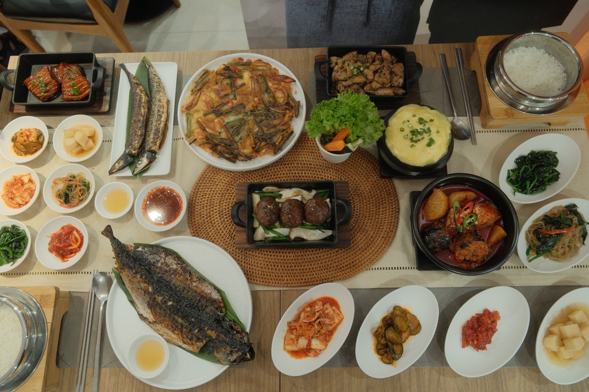 Overhead Sansok dinner spread with grilled fish, tteokgalbi and banchan