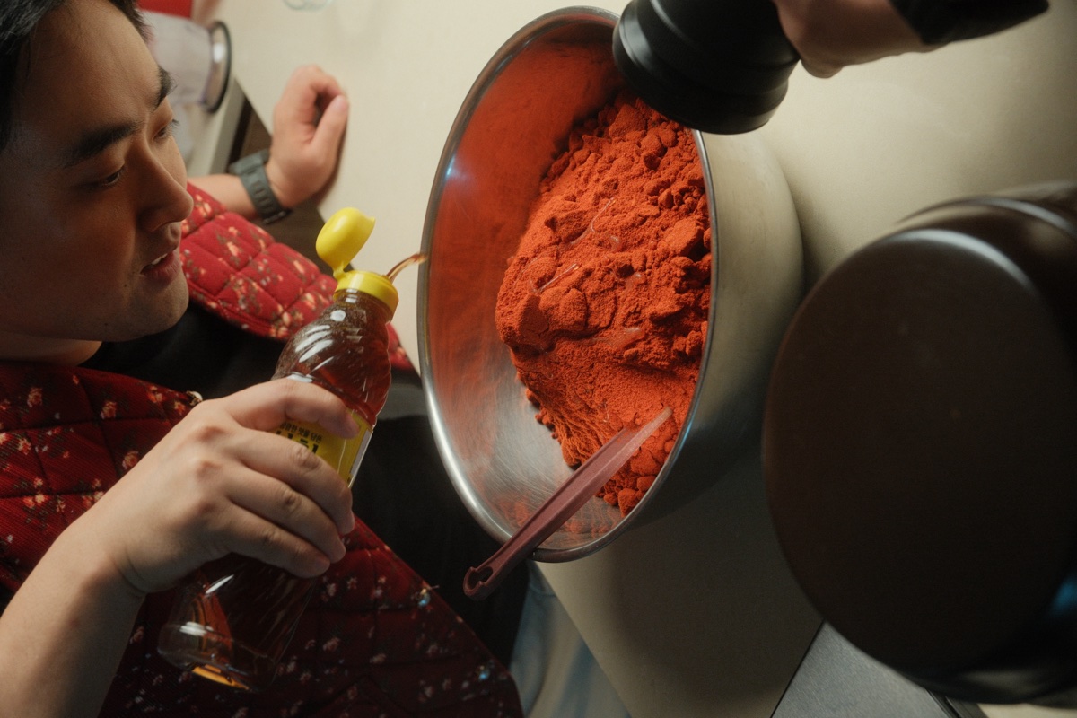 A liquid ingredient being poured into the bowl of gochugaru