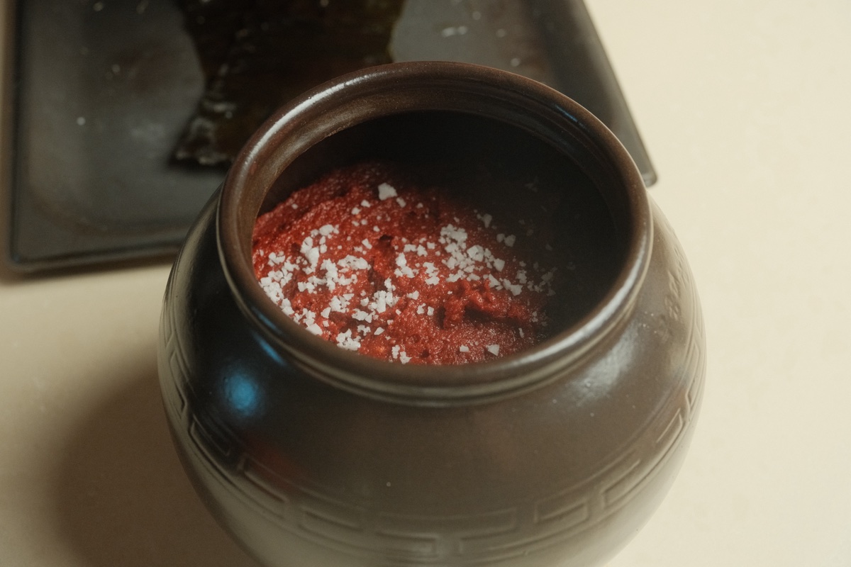 The fermentation jar filled with gochujang and topped with coarse sea salt