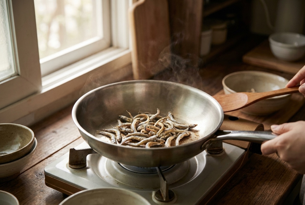 Dried anchovies toasting in a dry pan